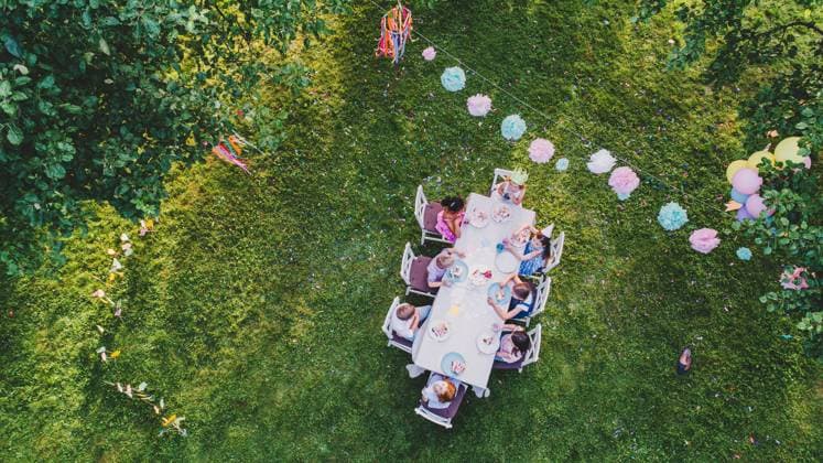 IMAGO Creative: Sommer, Sommertage im Garten Aerial view of small children sitting at table on summer garden party. Aerial view of small children sitting at table on summer garden party, birthday celebration concept. model released Copyright: xx Big_Kids_Drone_11
