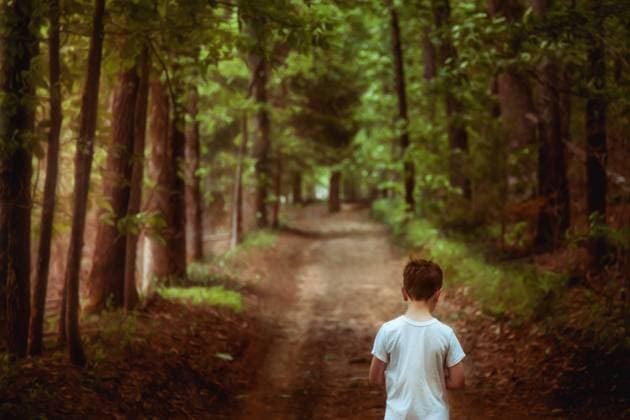 Boy walking along a wooded path with sunlight streaming in Tulsa, Oklahoma, United States CR_KRRY231227-1311421-01 ,model released, Symbolfoto