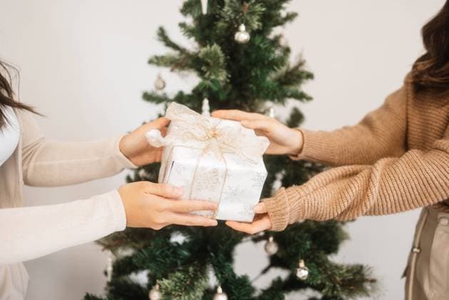 Gift Giving by the Christmas Tree Edmonton, Alberta, Canada R_DVQR240105-1317335-01 ,model released, Symbolfoto