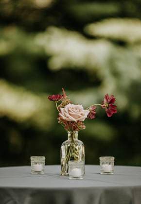 close up of vase with flowers and candles at a wedding reception Scarborough, Maine, United States R_SSNF240120C-1300146-01