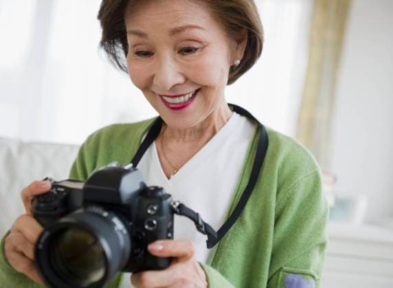 Japanese woman holding digital camera Jersey City, New Jersey, USA, 21.12.2023, model released, TTBB_BLD080838.jpg, 60-64 years, aging, asian ethnicity, brunette, camera, checking, color image, creativity, day, digital camera, enjoying, front view, happy, head and shoulders, hobby, holding, horizontal, indoors, japanese ethnicity, learning, leisure activity, looking down, memories, one person, people, photographer, photographing, photography, retirement, senior adult, senior adult woman, single object, slr, smiling, technology, viewing, minority, minorities60s, 60-65, 60-70, 60s, 65-70, 70s, 70-75, 70-80, 70s, 75-80, ageing, appreciating, asian, brown hair, cheerful, color, colour, creative, daylight, daytime, elderly, enjoyment, examining Copyright: xJGI JamiexGrillx