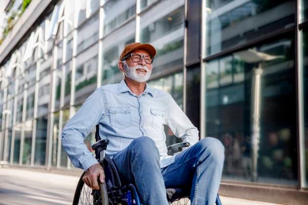 Smiling senior man sitting in wheelchair on footpath model released, Symbolfoto, IKF01382
