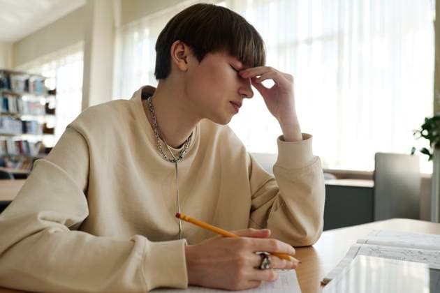 Tired student rubbing eyes in library model released, Symbolfoto property released, DSHF01510