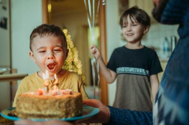 Creative Highlights Symbolbilder Boy blowing candles on birthday cake at home model released, Symbolfoto property released, ANAF02630