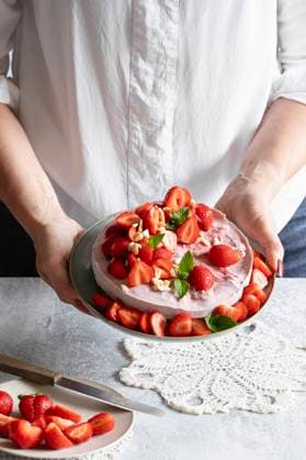 Hands of woman holding plate with ready-to-eat vegan strawberry tart model released, Symbolfoto, EVGF04457