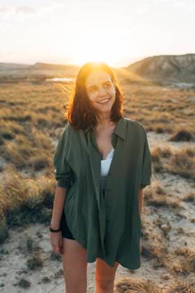 Creative Highlights Symbolbilder Smiling young woman walking on desert landscape at sunset model released, Symbolfoto, DAMF01248