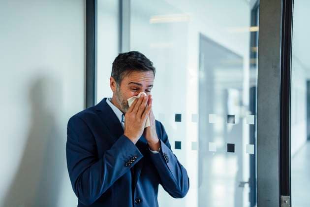Businessman blowing nose on handkerchief in office model released, Symbolfoto property released, JOSEF22502