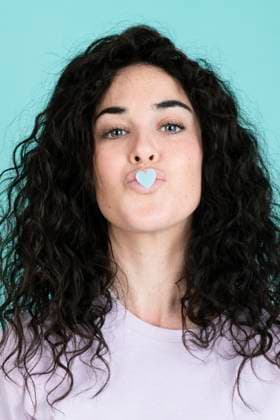 Creative Highlights Symbolbilder Woman puckering with heart shaped sticker on lips against turquoise background model released, Symbolfoto, LMCF00849