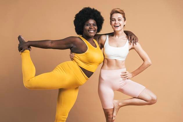 Creative Highlights Symbolbilder Happy young woman with arm around smiling friend against beige background model released, Symbolfoto, OIPF03751