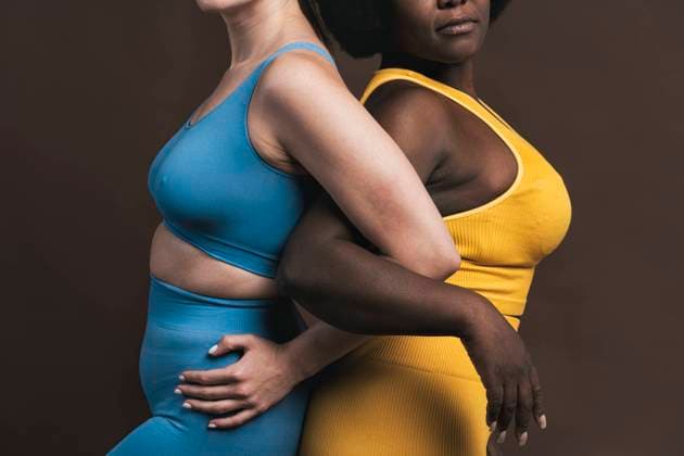 Creative Highlights Symbolbilder Young women standing back to back with arm in arm against brown background model released, Symbolfoto, OIPF03769