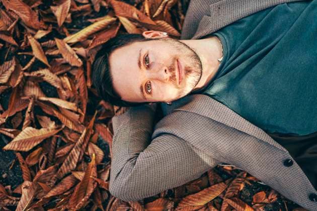 Smiling young man relaxing on autumn leaves model released, Symbolfoto, SVCF00434