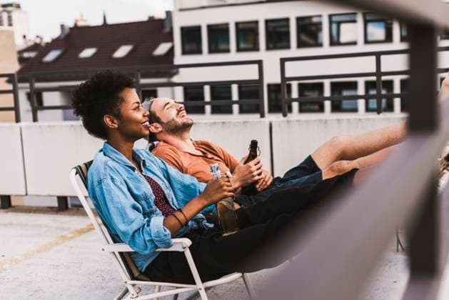 Young couple sitting with beer on rooftop model released, Symbolfoto, UUF30756