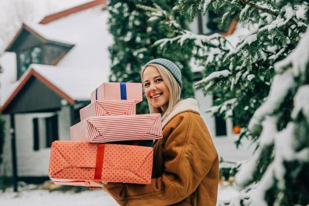 Happy woman carrying Christmas gifts near tree model released, Symbolfoto, VSNF01517