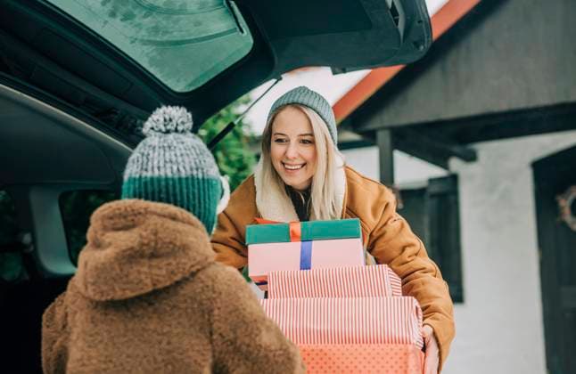 Smiling mother showing Christmas presents to son near car model released, Symbolfoto, VSNF01526