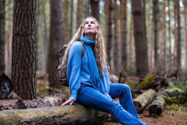 Thoughtful beautiful woman sitting on log in Cannock chase forest model released, Symbolfoto, WPEF08100