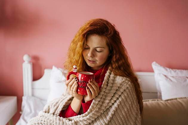 Redhead woman holding coffee mug on bed at home model released, Symbolfoto property released, YBF00358