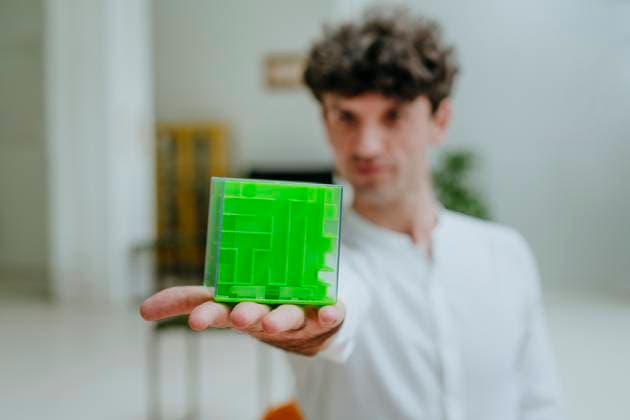 Creative Highlights Symbolbilder Businessman showing cube shape maze in office model released, Symbolfoto property released, YTF01567