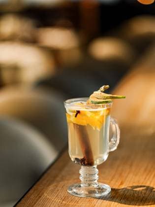 mulled wine drink made from white wine Glass with hot natural mulled cider drink made with cinnamon stick, mango and spices, on bar counter in restaurant interior. Warming beverage for cold season. Autumn or Christmas seasonal drink Copyright: xZoonar.com OlgaxSergeevax 20894424