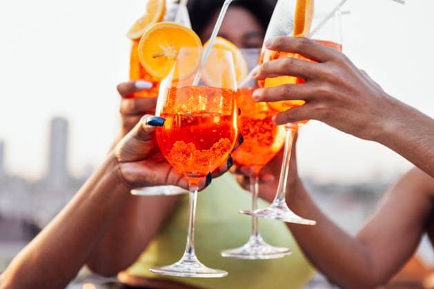 Close up of female and male hands holding elegant glasses with long stem of aperol and clink them. Close up of female and male hands holding elegant glasses with long stem of aperol and clink them. Making a celebratory toast with delicious citrus alcohol cocktails with slice of orange. Party. ,model released, Symbolfoto Copyright: xZoonar.com DashaxPetrenkox 20906500 ,model released, Symbolfoto ,property released
