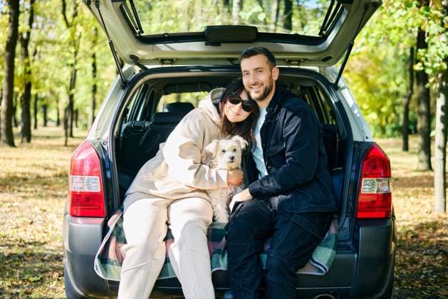 IMAGO Creative, Ostern, Bräuche, Osterspaziergang Loving couple embracing hugging with their white dog in the hatchback of a car relaxing in a sunny woodland Loving couple embracing hugging with their white dog in the hatchback of a car relaxing in a sunny woodland. Family, vacation, holidays, travel concept ,model released, Symbolfoto Copyright: xZoonar.com ViktorxGladkovx 20926673 ,model released, Symbolfoto ,property released