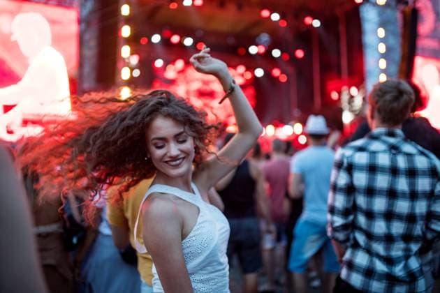 Beautiful young woman dancing at summer festival. Beautiful young woman with friends dancing at summer festival. model released Copyright: xx Uprising_2019_2007