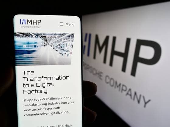 Person holding cellphone with webpage of company MHP Management- und IT-Beratung GmbH on screen. Stuttgart, Germany - 08-20-2023: Person holding cellphone with webpage of company MHP Management- und IT-Beratung GmbH on screen with logo. Focus on center of phone display. Copyright: xZoonar.com TimonxSchneiderx 21005451