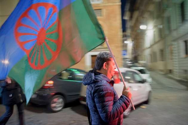 January 27, 2024, Rome, Italy: A man carries the international flag of the Roma people during the procession in memory of the forgotten victims of the Holocaust on Remembrance Day in Rome. Torchlight procession in Rome in memory, in addition to the massacre of the Jewish people, of all the victims of the forgotten massacres: Roma, Sinti, homosexuals, transsexuals, disabled people, religious people and political opponents deported and exterminated in Nazi concentration camps during the Second World War. The initiative was organized by Opera Nomadi together with the National Association of Partisans of Italy (ANPI), by the Mario Mieli Homosexual Club and many other Committees and Associations and sponsored by the Municipality of Rome Capital. - ZUMAv147 20240127_zip_v147_007 Copyright: xMarcelloxValerix