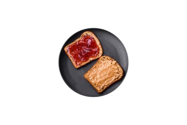 Nutritious sandwiches consisting of bread, raspberry jam and peanut butter Nutritious sandwiches consisting of bread, raspberry jam and peanut butter on a black ceramic plate on a dark concrete background Copyright: xZoonar.com TetianaxChernykovax 21075133