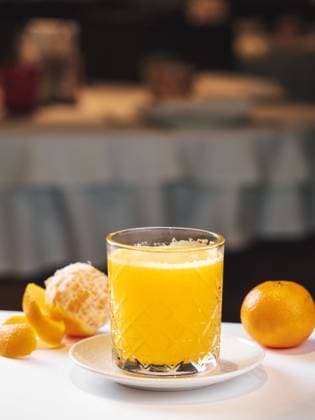 Mandarin fresh juice Mandarin fresh juice in restaurant interior. Yellow mandarin shake served for drink. Hot day refreshing beverage. Sweet mandarin juice in glass. Glass of fresh yellow mandarin cocktail or juice, vertical with copy space Copyright: xZoonar.com OlgaxSergeevax 21105858