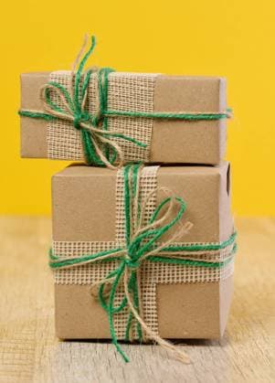 The box is packed in brown craft paper and tied with a rope on a beige background, gift The box is packed in brown craft paper and tied with a rope on a beige background, gift Copyright: xZoonar.com DANKOxNx 21125591