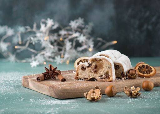 Christstollen, traditonal christmas cake with nuts, raisons, marzipan on a blue background, empty space for text 2773503 RECORD DATE NOT STATED