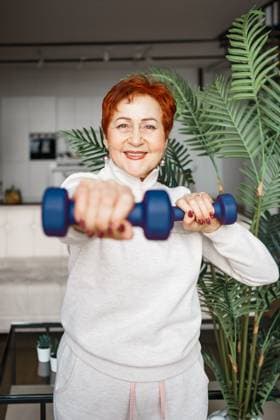 Creative Highlights Symbolbilder Older Caucasian woman works out with dumbbells at home Poltava, Poltava Oblast, Ukraine R_DHLJFN220202-911754-01 ,model released, Symbolfoto