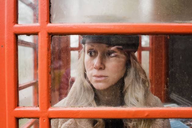 Creative Highlights Symbolbilder woman looking through an English telephone box on a cold day Petersfield, England, United Kingdom R_RABE22012619-909292-01 ,model released, Symbolfoto