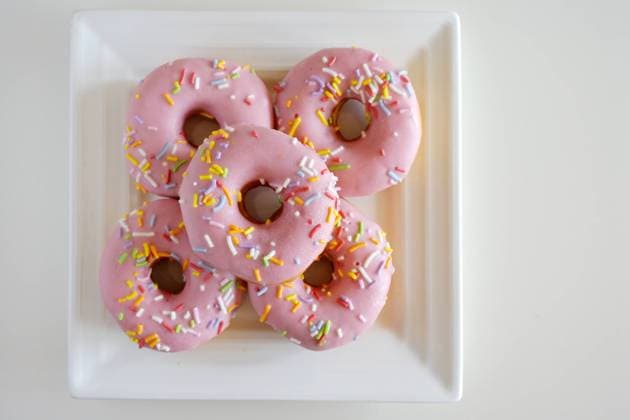Five Sweet Pink Doughnuts Confection Served on a Square White Plate Flat lay view of five sweet pink doughnuts confection served on a square white plate. EDITORIAL USE ONLY Copyright: xx RafaelxBen-Arix cewitness039617