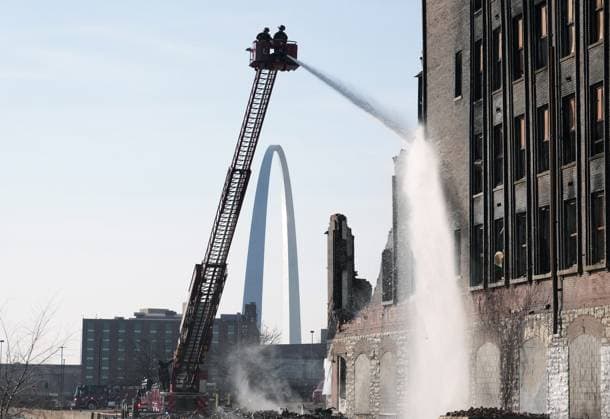 News Themen der Woche KW05 News Bilder des Tages With the Gateway Arch nearby, St. Louis firefighters on a hook and ladder truck use a stream of water, searching for hot spots, during a four alarm fire in vacant warehouse in St. Louis on Saturday, February 3, 2024. Over 85 firefighters fought the fire for most of the day.  SLP2024020307 BILLxGREENBLATT
