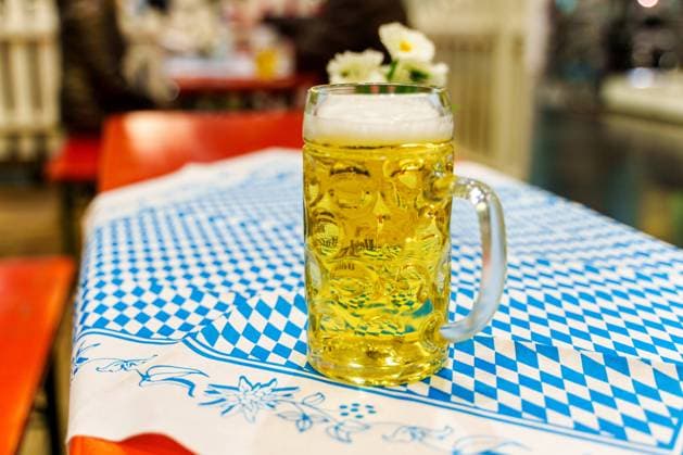 Augsburg, Bavaria, Germany - 2 February 2024: A measure of wheat beer on a beer table with tablecloth in Bavarian colors at a Bavarian festival *** Eine Maß Weißbier auf einem Biertisch mit Tischdecke in Bayern farben bei einem bayerischen Fest