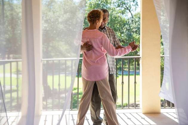 Older couple dancing on porch overlooking green lawn , seen through sheer curtains Dallas TEXAS USA  Copyright: xStewartxCohenxPicturesx 4009-18365533 ,model released, Symbolfoto