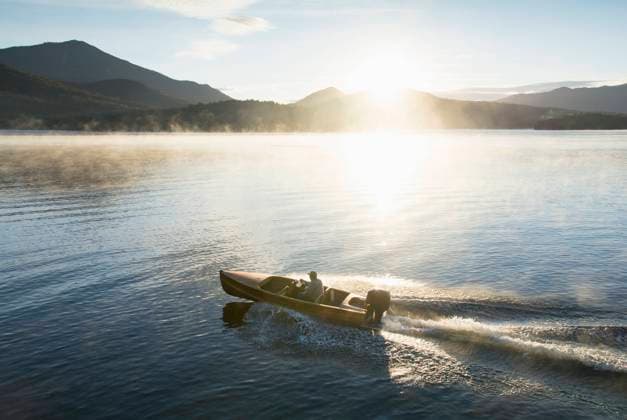 USA, New York, Lake Placid, Man in motorboat on Lake Placid , 22.09.2016, model released, TTBB_ti0027_00716.jpg, Lake, Caucasian Ethnicity, Motorboat, Outdoors, Day, Getting Away From It All, Summer, Vacations, Tranquility, Horizontal, Sun, Scenics, Fog, Mountain Range, On The Move, Travel Destinations, Morning, Lake Placid, Leisure Activity, Wake - Water, Solitude, Reflection, Speed, One Person, One Senior Man Only, 65-69 Years, USA, New York Copyright: xChrisxHackettx