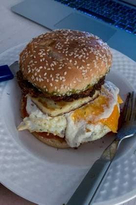 A vertical shot of vegetarian halloumi egg burger with a fork on a plate 2921141