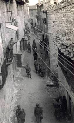 View of a street in Horta de S. Juan taken from the top of a building. Soldiers in uniform and a few civilians can be seen walking along the street (b w photo) 1249999 View of a street in Horta de S. Juan taken from the top of a building. Soldiers in uniform and a few civilians can be seen walking along the street (b w photo) by Unknown photographer, (20th century); (add.info.: Unidentified Author Spain); Fratelli Alinari Museum Collections, Florence, Italy. Copyright: xFratellixAlinarixMuseumxCollections,xFlorence,xItalyx xBridgemanxImagesx 1249999