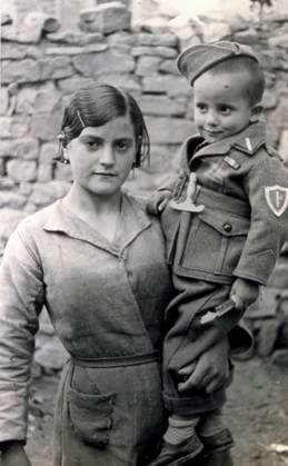 Three-quarter-length portrait of a young woman, poorly dressed, holding a child dressed as a solder in her arms. The child has a small wooden sword on his jacket, 08 1938 (b w photo) 1250086 Three-quarter-length portrait of a young woman, poorly dressed, holding a child dressed as a solder in her arms. The child has a small wooden sword on his jacket, 08 1938 (b w photo) by Unknown photographer, (20th century); (add.info.: Unidentified Author Spain); Fratelli Alinari Museum Collections, Florence, Italy. Copyright: xFratellixAlinarixMuseumxCollections,xFlorence,xItalyx xBridgemanxImagesx 1250086