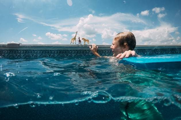 Boy in swimming pool playing with zoo animal toys McClure, Illinois, United States CR_WEKW240205BB-1347876-01 ,model released, Symbolfoto