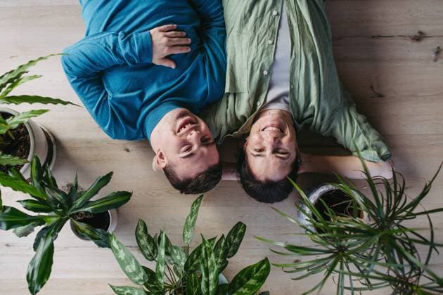 Portrait of young man with Down syndrome with his mother at home, lying on floor. Concept of love and parenting disabled child. Banner with copyspace. Top view of young man with Down syndrome with his mother at home, lying on floor. Morning routine for man with Down syndrome genetic disorder. model released