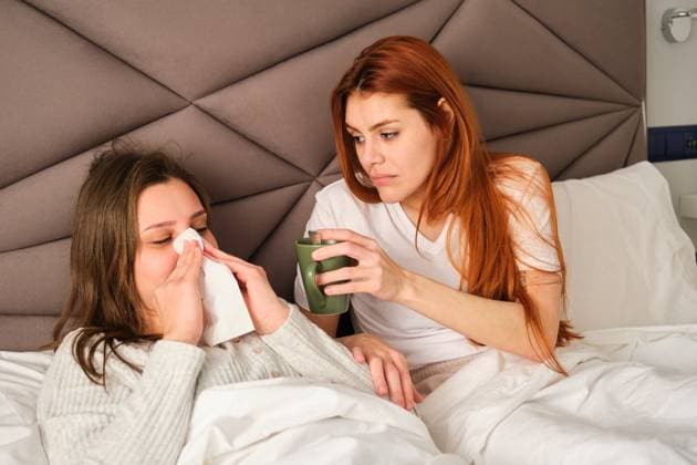 IMAGO Creative, Gesellschaft, Leisure Sickness Brazilian woman blowing her nose in a tissue while her wife take care. Madrid, Community of Madrid, Spain CR_CRVI240209-1349007-01 ,model released, Symbolfoto
