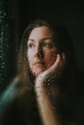 Creative Highlights Symbolbilder Close up of woman looking out window covered in rain drops. Kingston, Ontario, Canada CR_DOHO240207H-1345047-01 ,model released, Symbolfoto