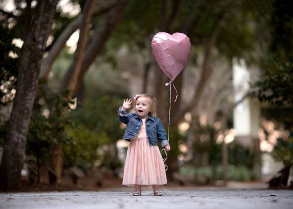 Creative Highlights Symbolbilder Little joyful girl waving holding a pink valentine s day balloon Destin, Florida, United States R_NYRF240209AD-1350345-01 ,model released, Symbolfoto