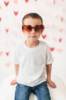 Creative Highlights Symbolbilder Happy boy wearing heart shaped sunglasses on heart garland background Chicago, Illinois, United States R_AKAO2402129F-1342681-01 ,model released, Symbolfoto