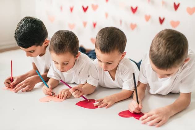 Children writing and coloring on heart notes on floor Chicago, Illinois, United States R_AKAO2402129F-1342692-01 ,model released, Symbolfoto