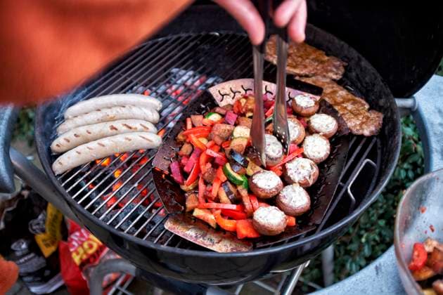 Grillen Auf einem Rundgrill werden gleichzeitig Wuerstchen, Steaks und Gemuese gegrillt. Essen NRW *** Barbecue at a Round grill become simultaneously Sausages, Steaks and Vegetables grilled Food NRW