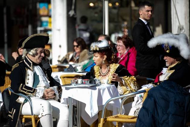 (240214) -- VENICE, Feb. 14, 2024 -- People wearing costumes take a rest on the last day of the Venice Carnival in Venice, Italy, Feb. 13, 2024. ) ITALY-VENICE-CARNIVAL LixJing 